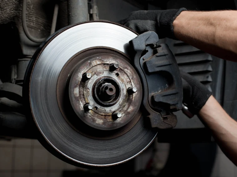 Closeup of car mechanic repairing brake pads.